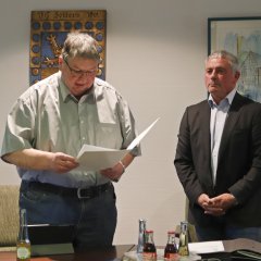 Der Erste Beigeordnete Hanno Steindorf liest die Ernennungsurkunde von Stadtbürgermeister Rolf Jung (re.) vor